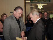 Robert McEllrath, left, president of the International Longshore and Warehouse Union (ILWU), confers with attorney Tom Phelan after surrendering to authorities in Kelso on Monday.  McEllrath was cited and released on misdemeanor charges of trespassing in the second degree and blocking or delaying a train, both related to a protest at the Port of Longview, Wash., on Sept.