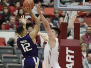 Washington's Andrew Andrews (12) shoots against Washington State's Conor Clifford during the first half of an NCAA college basketball game, Saturday, Jan. 9, 2016, in Pullman, Wash.