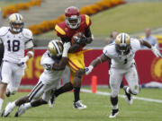 Southern California's Marquise Lee is tackled by Washington's Desmond Trufant after a 14-yard gain in the second half Saturday.