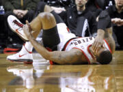 Portland Trail Blazers forward LaMarcus Aldridge holds his ankle after landing on another players' foot during the first quarter of their NBA basketball game against the Washington Wizards in Portland Tuesday.