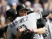 Chicago White Sox starting pitcher Philip Humber, center, is mobbed by teammates after pitching a perfect baseball game against the Seattle Mariners on Saturday at Safeco Field.