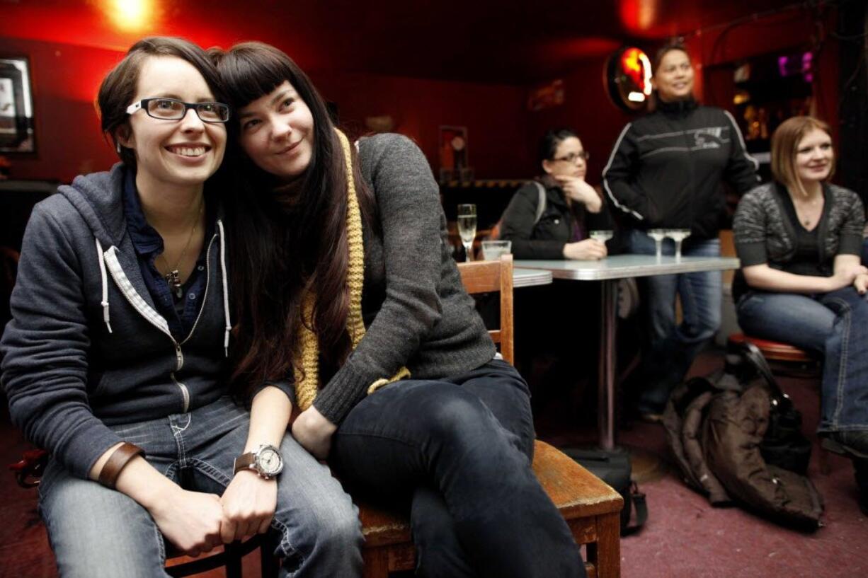 Elizabeth Scallon, left, and Shena Lee, listen to a toast Monday at the Wild Rose in Seattle celebrating Washington allowing same-sex couples to marry. Bars throughout Seattle and the rest of the state celebrated Gov. Chris Gregoire's signing of the bill legalizing gay-marriage earlier in the day.