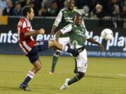 Chivas USA's Nick LaBrocca kicks the ball as Portland Timbers' Diego Chara defends in the second half.