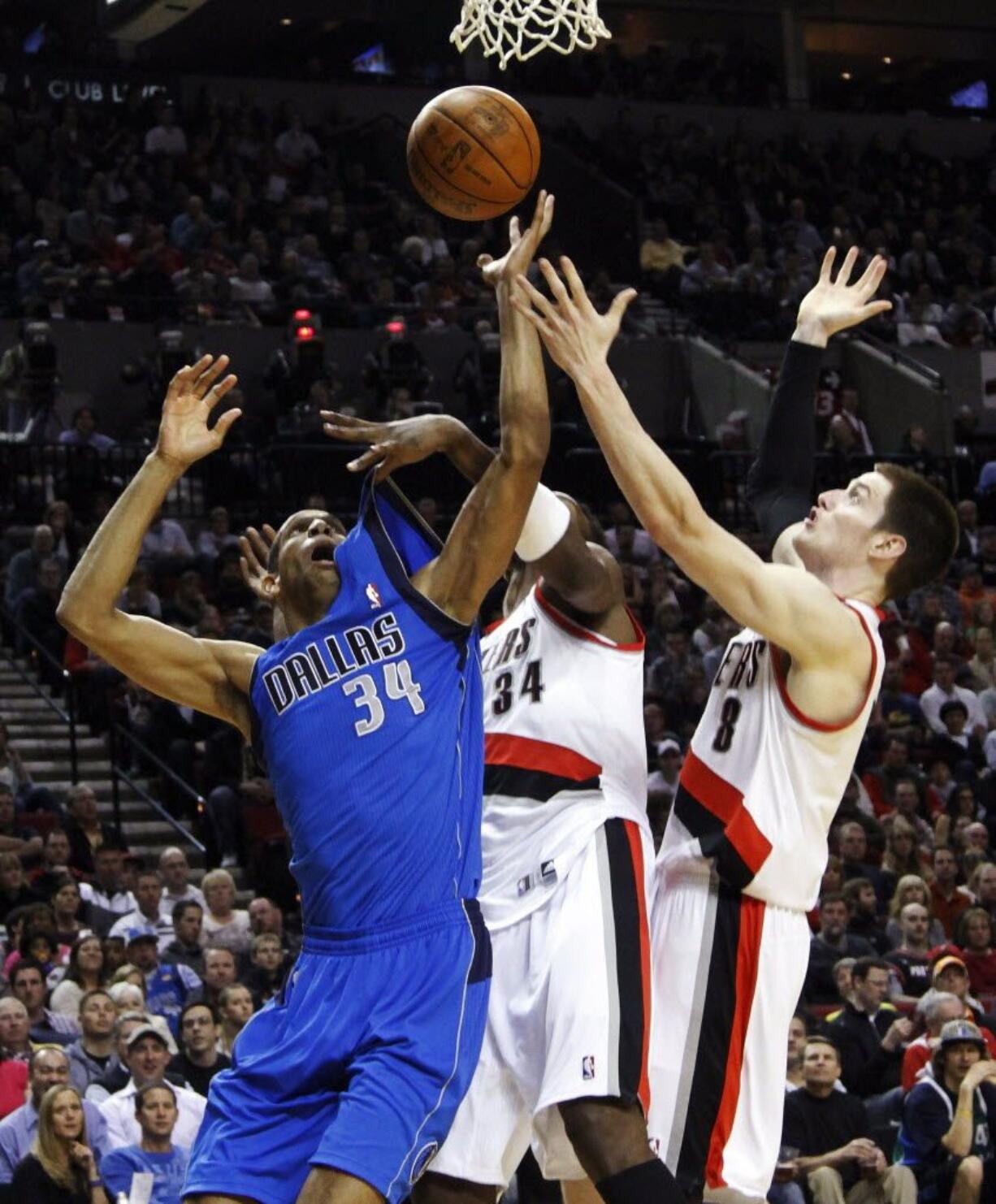 Dallas forward Brandan Wright, left, battles for a rebound with the Portland's Luke Babbitt, right, and Hasheem Thabeet during the first half Friday.