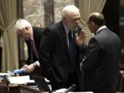 Sen. Don Benton, R-Vancouver, center, talks with Sen. Jeff Baxter, R-Spokane, right, on the Senate floor on April 13.