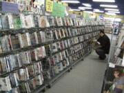 Dustin Chipchase, manager at Movie Movers' Hazel Dell location, stocks the shelves.