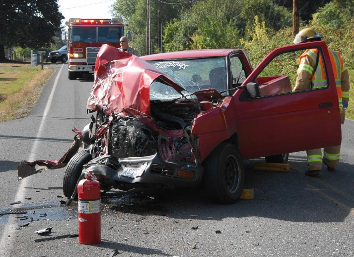 Clark County Fire &amp; Rescue Firefighter-paramedic Robert Harvey checks a pickup Monday after it collided with another truck at 5001 N.E.