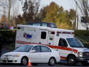 An American Medical Response ambulance leaves the scene after a bank robbery suspect was shot by police while trying to flee near the Vancouver Mall on Dec. 1.