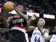 Portland Trail Blazers' Jonny Flynn (3) tries to pass around Memphis Grizzlies' Dante Cunningham (44) and Josh Selby during the first half in Memphis, Tenn., on Saturday.