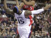 Portland Trail Blazers center Marcus Camby, top, drives to the basket and is fouled by Sacramento Kings center DeMarcus Cousins during the first quarter Thursday.