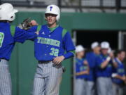 Mountain View's Dean Taylor, left, congratulates teammate Jake Shelley as he crosses home plate to make it 2-0 in the third inning against Camas on Thursday.