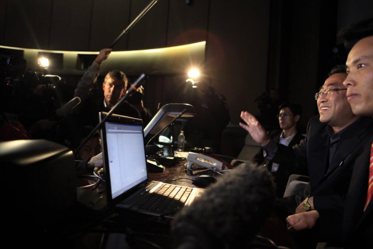 A North Korean press center worker, second from right, tries to appease foreign journalists desperate for news on the launch of a long-range rocket in Pyongyang, North Korea, on Friday.