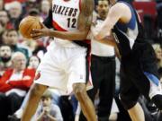 Minnesota Timberwolves' Kevin Love, right, defends against Portland Trail Blazers' LaMarcus Aldridge (12) in the first quarter Sunday.