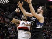 Minnesota's Kevin Love (42) goes to the basket against Portland's LaMarcus Aldridge during the second half Saturday.