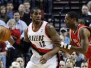 Portland Trail Blazers forward LaMarcus Aldridge, left, looks to pass against Houston Rockets center and former teammate Marcus Camby during the first quarter Monday.