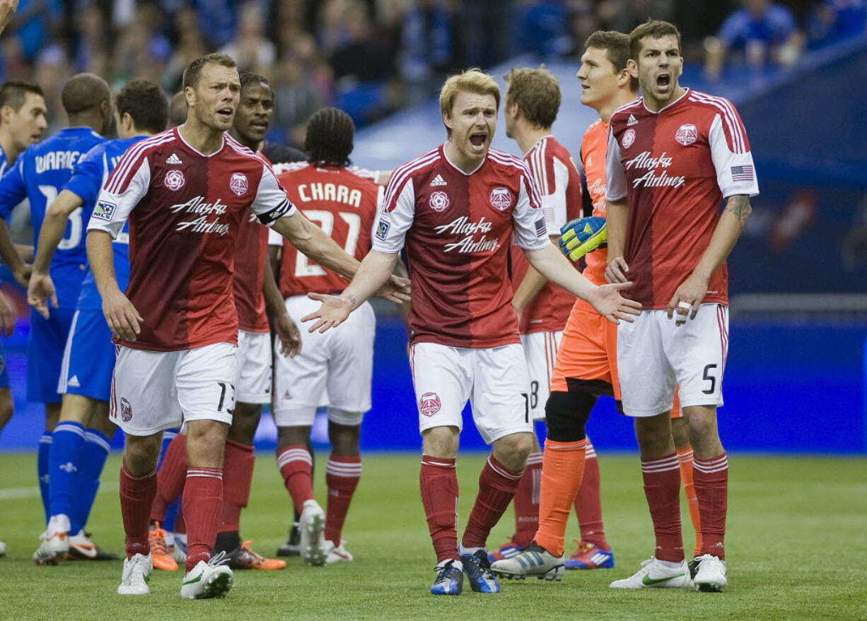 Portland Timbers' Jack Jewsbury (13), Steven Smith (14) and Eric Brunner (5) react after the referee awarded a penalty kick to the Montreal Impact during second half Saturday.