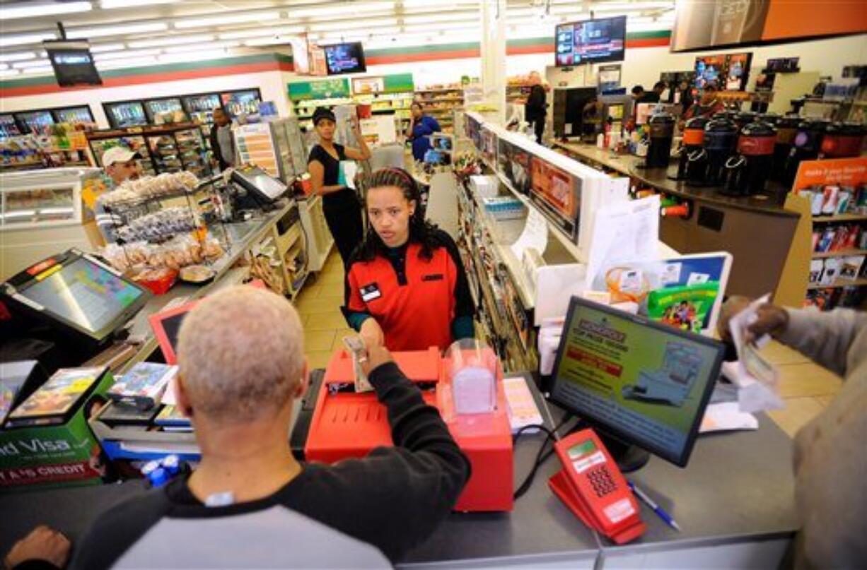 Dinkensh Dubiyo, center, sells lottery tickets at a Baltimore 7-Eleven store where one of the winning lottery tickets for the record-breaking $640 million Mega Millions jackpot was sold Saturday.