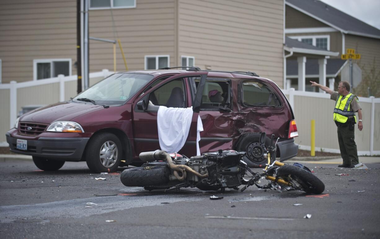 A Clark County Sheriff's deputy directs traffic as police investigate a fatal accident involving a minivan and motorcycle Tuesday morning.