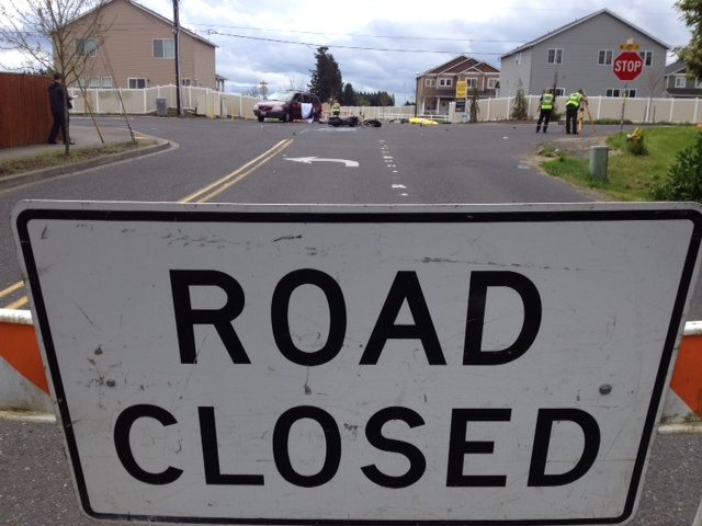 A road closed sign on the north side of Northeast 58th Avenue looks south toward Northeast 63rd Street on Tuesday after a man was fatally injured when a motorcycle and van collided in the intersection.