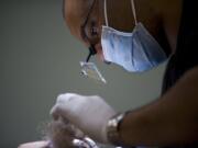 Lead NeoGraft Technician Robert Alvarado makes incisions in a 66-year-old female patientOs scalp where her transplanted hair follicles will be placed, at Salmon Creek Plastic Surgery