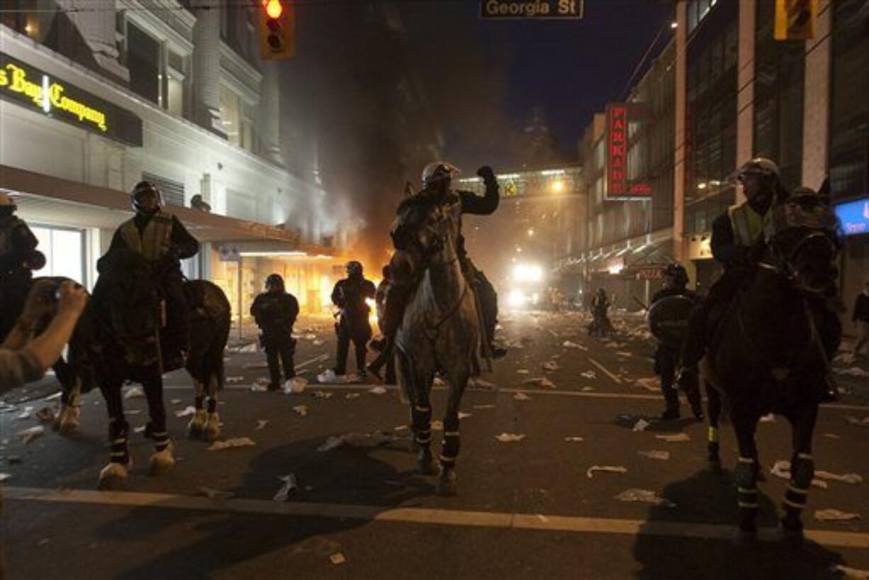 Police on horseback move down a street during a riot following the Vancouver Canucks being defeated by the Boston Bruins in the NHL Stanley Cup Final in Vancouver, British Columbia, Wednesday, June 15, 2011. Angry, drunken revelers ran wild Wednesday night after the Vancouver Canucks' 4-0 loss to Boston in Game 7 of the Stanley Cup finals, setting cars and garbage cans ablaze, smashing windows, showering giant TV screens with beer bottles and dancing atop overturned vehicles.