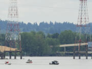 Rescue boats search the area Monday where a fishing boat capsized on the Columbia River near Camas. Three people on the boat went into the water.