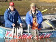 State biologist John Weinheimer, left, and Buzz Ramsey of Yakima Bait show two limits of rainbow trout caught  last year at Rowland Lake east of Bingen in Klickitat County.