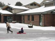 Dan Friesz, left, pulls his son, Nathan, 9, in a sled at Franklin Elementary School Wednesday.