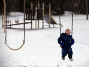 Maximus Cieloha, 4, of Vancouver watches as snowflakes fall from the sky while playing at Wy’East Community Park with his mom, Carissa, not pictured, on Sunday morning, January 3, 2016.