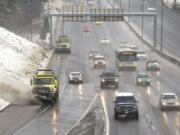 Snowplows work at clearing Interstate 5 for the morning commute on Thursday.