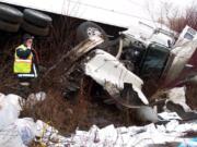 Jeff Lewis of the state Department of Ecology surveys the scene of a wreck that spilled an estimated 280 gallons of diesel and oil in and around the Little Klickitat River early Tuesday. The spill, caused by an overturned semi truck, happened just off U.S.