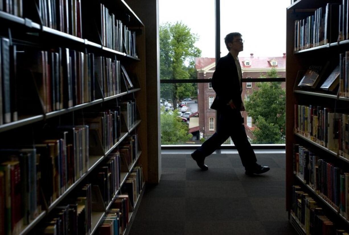 A patron walks past rows of books on the fifth floor during the grand opening of the Vancouver Community Library on Sunday July 17, 2011.