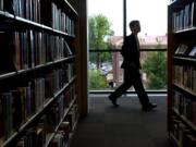 A patron walks past rows of books on the fifth floor during the grand opening of the Vancouver Community Library on Sunday July 17, 2011.