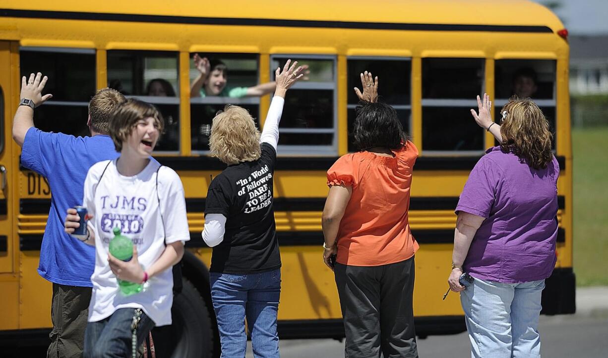 Staff and faculty at Thomas Jefferson Middle School wave goodbye to buses filled with students as they head home for summer break June 22, 2010 in Vancouver, Washington.