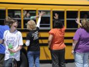 Staff and faculty at Thomas Jefferson Middle School wave goodbye to buses filled with students as they head home for summer break June 22, 2010 in Vancouver, Washington.