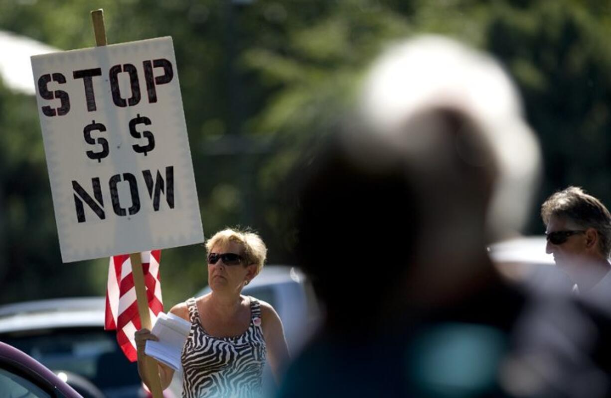 Lynn Costello of Vancouver holds up a sign Thursday during a Tea Party rally in front of Rep. Jamie Herrera Beutler's Vancouver office.