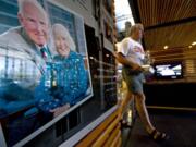 Rolf Adams, of Vancouver, walks past a photograph of Ed and Mary Firstenburg inside the lobby of the Firstenburg Community Center on Aug. 23, 2010.