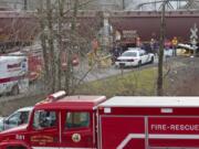 Emergency personnel transport an injured passenger to an ambulance from the shuttle vehicle which was hit by a northbound train at a private crossing at the Longview Junction near the Harry Morgan Bridge in Kelso in March, 2011.