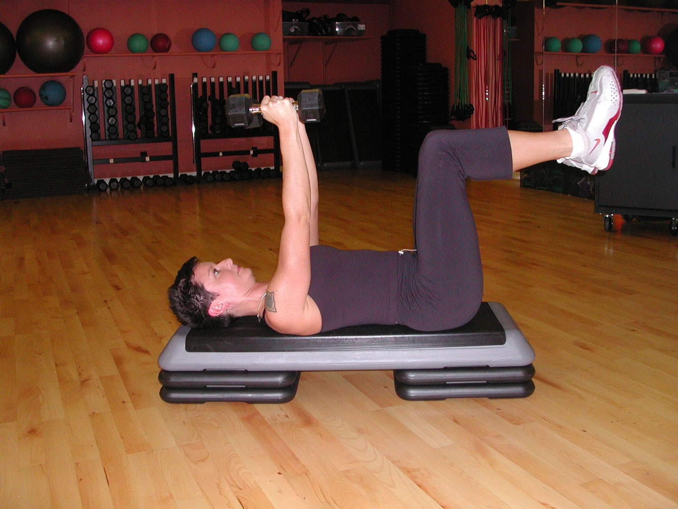 Tricep extension. Lay on your back with feet suspended in the air so that upper thighs are perpendicular to the floor and lower legs are parallel to the floor (90-degree angle at hips and knees). Keep your abdominals pulled inwards throughout the entire exercise and back neutral and completely stable.