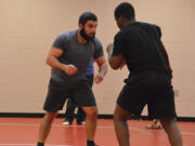 Fort Vancouver High School wrestling coach Saleh Batroukh, left, does a drill with one of his wrestlers during practice on Wednesday.