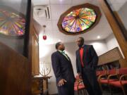 The Rev. Cleveland Mason, a pastor at Perkins Square Baptist Church, left, and the Rev. Domanic Smith, pastoral outreach coordinator at Sinai Hospital, talk in the Sinai chapel in Baltimore.