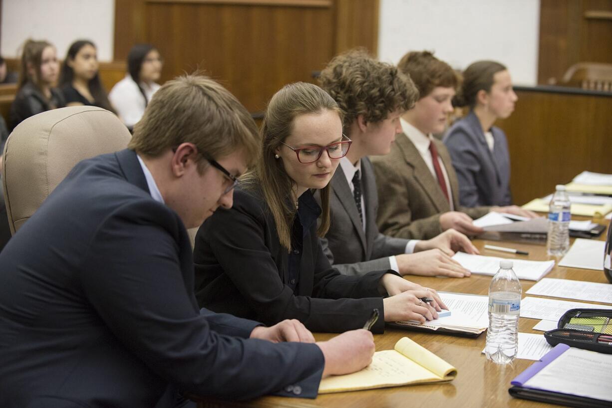 Camas High School students Bracy Ratcliff, 17, from left, Baylee Allen, 18, and Alex McOmie, 17, act as defense attorneys during Clark County&#039;s district mock trial tournament on Thursday afternoon at the Clark County Courthouse. The Camas team is eligible to compete in the state mock trial tournament in Olympia next month.