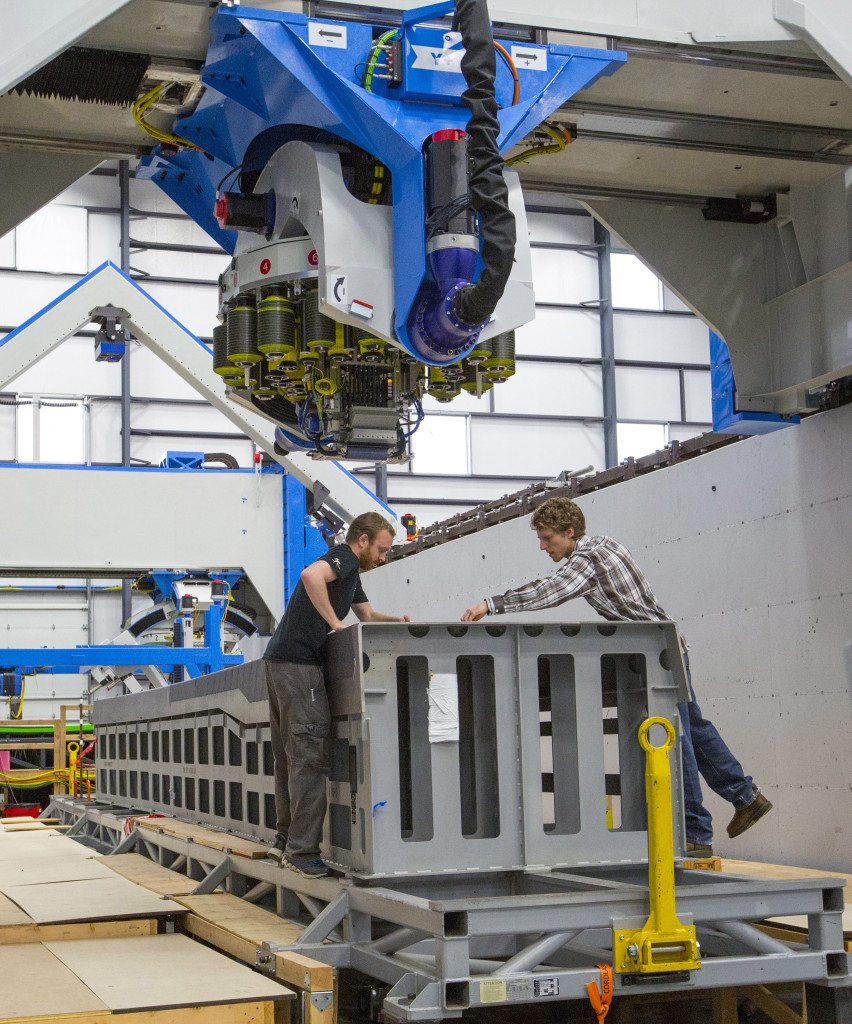 Control engineers Brad Davis, left, and Kyle Walker check the placement of carbon fiber by the machine that is making test wing spars for the Boeing 777X.