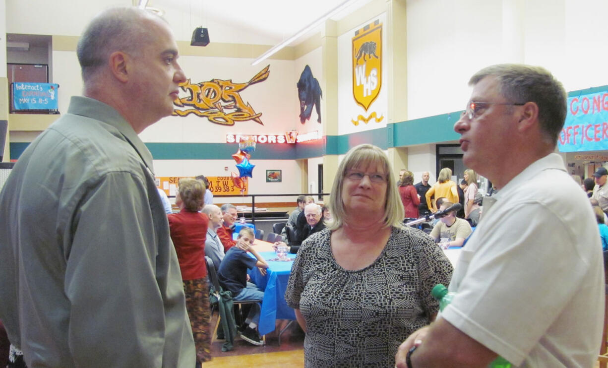 Tom Davis (left) talked with Washougal Police Department Administrative Assistant Pat King (center) and former Police Chief Bob Garwood (right), Saturday night at Washougal High School.