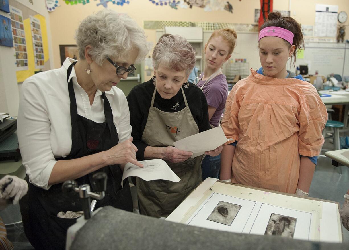 Art teacher Fae Moeller, from left, checks a print with Sharri LaPierre of North Bank Artists, eighth-grader Arianna Bollens, 13, and seventh-grader Darrian Gunderson, 12, on Thursday at Thomas Jefferson Middle School.