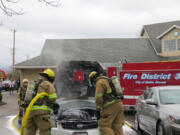 Firefighters douse a car fire at 15 S..W 20th Ave. in Battle Ground Monday morning.