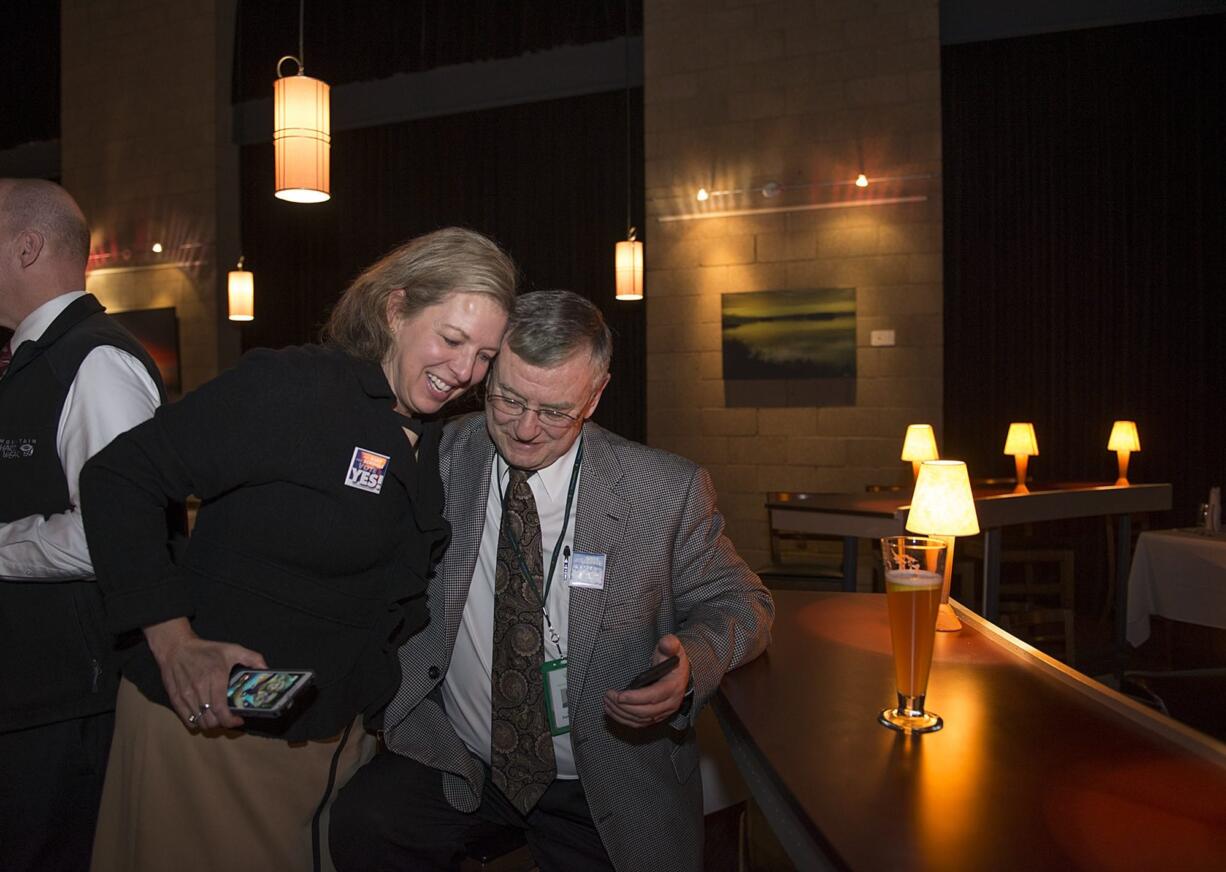 Evergreen School District communications director Gail Spolar offers a hug to Superintendent John Deeder after election results were posted Tuesday night. Supporters gathered at Vinotopia in east Vancouver to celebrate the passage of a three-year school levy.