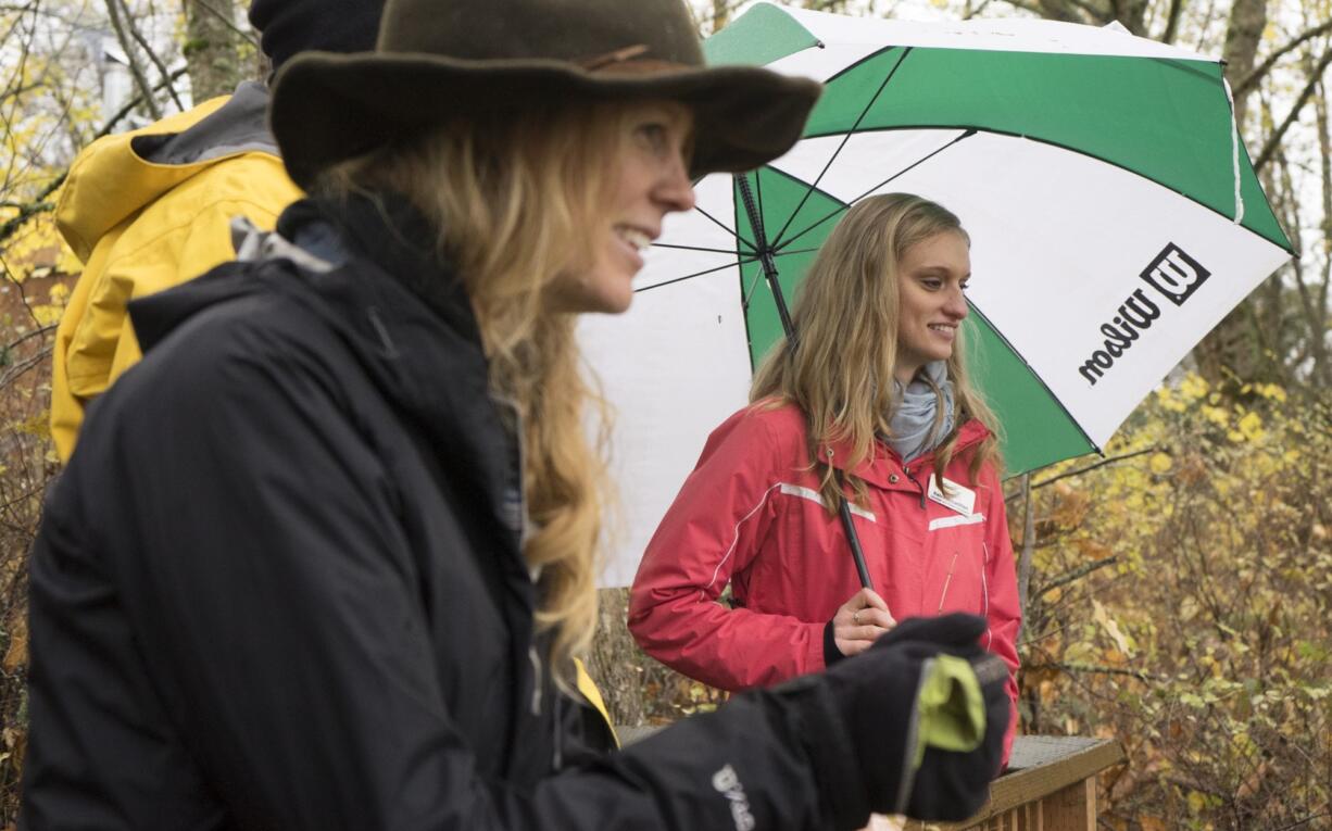 Kaley McLachlan, right, takes a minute to watch the chum salmon spawning ground along the Columbia River on Columbia Springs property with Jasmine Zimmer-Stucky and Jared Smith of Portland.