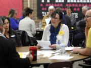 Stephanie McClintock, center, talks with other members at the GOP precinct caucus at Prairie High School on Saturday. McClintock said she hopes to see local Republicans work together this year to uphold conservative principles.