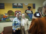 Artist Sue Clancy, left, gets her photo taken with longtime children’s justice advocate Pat Jollota at Monday’s mural unveiling. Clancy hopes her artwork will help to encourage children who are suffering from trauma and abuse.